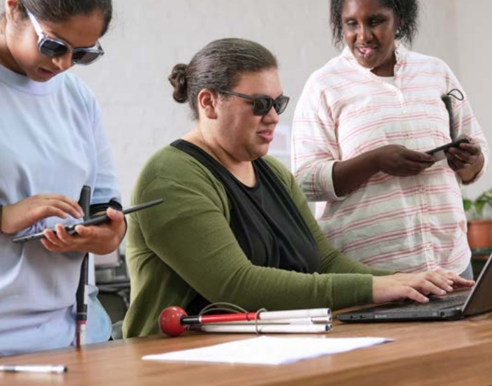Three people with visual impairment working in an office